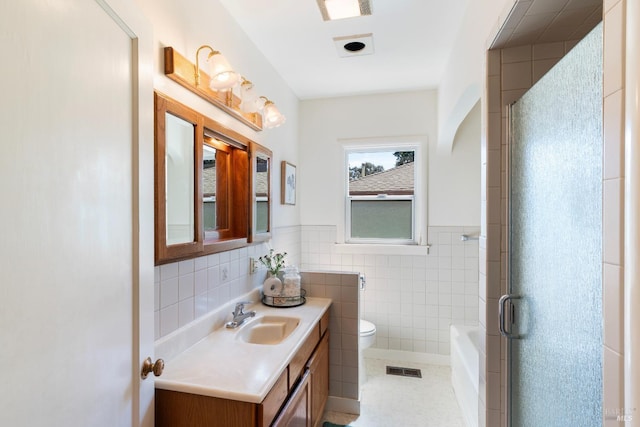 bathroom with visible vents, toilet, tile walls, wainscoting, and vanity