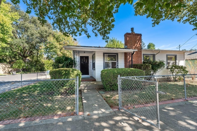 bungalow-style house featuring a fenced front yard, a chimney, and a gate