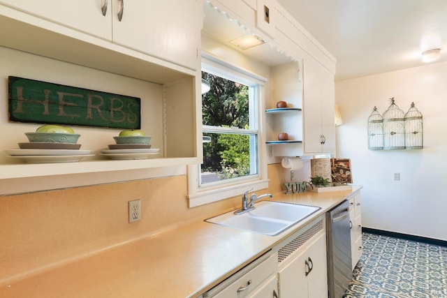 kitchen featuring baseboards, a sink, light countertops, white cabinets, and dishwasher