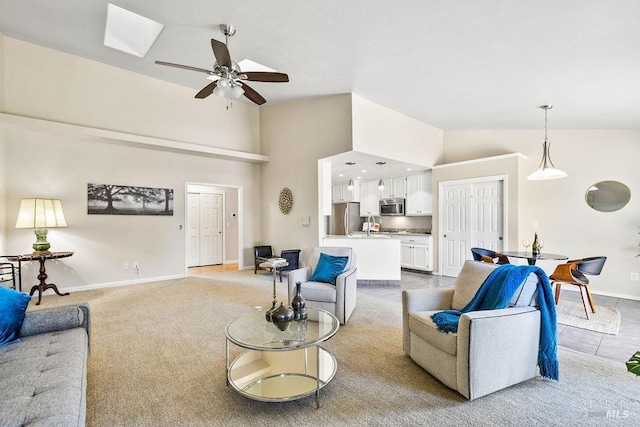 living room with carpet flooring, baseboards, a ceiling fan, and high vaulted ceiling