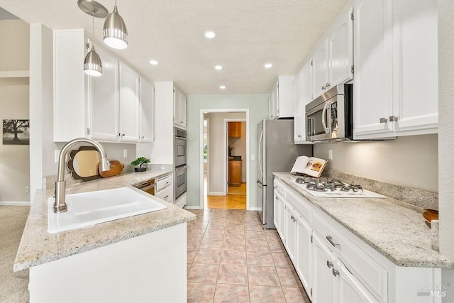 kitchen featuring light tile patterned flooring, recessed lighting, a sink, appliances with stainless steel finishes, and white cabinetry