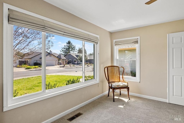 living area with visible vents, baseboards, carpet, and a residential view