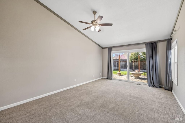 carpeted spare room featuring baseboards, crown molding, a ceiling fan, and vaulted ceiling