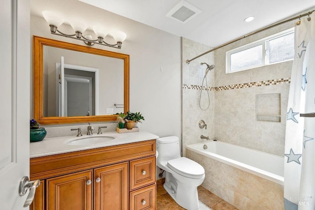 full bath with vanity, visible vents, tile patterned flooring, tiled shower / bath combo, and toilet