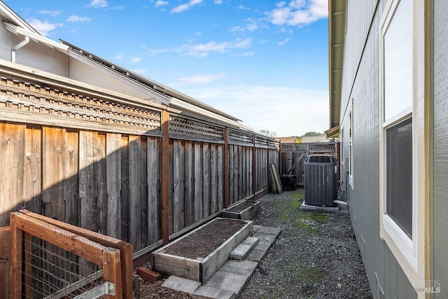 view of yard featuring cooling unit, a vegetable garden, and fence