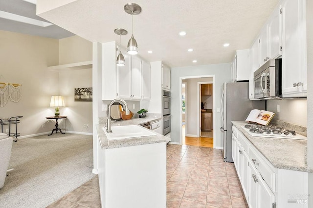 kitchen with light colored carpet, appliances with stainless steel finishes, light tile patterned flooring, white cabinets, and a sink