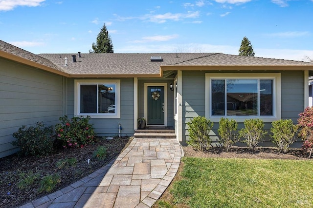 doorway to property featuring a shingled roof