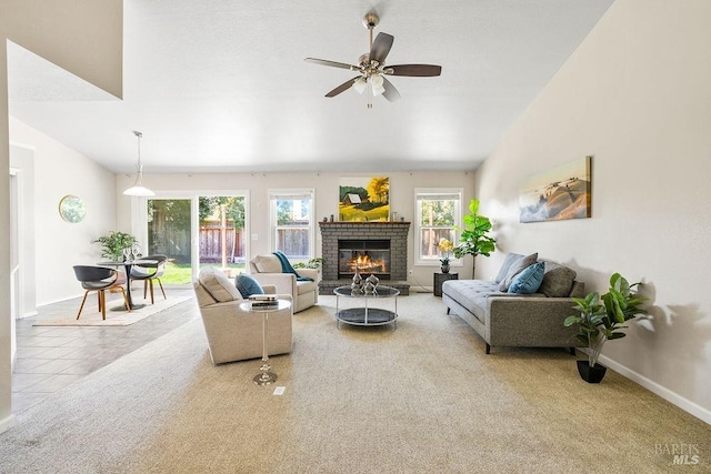 living area featuring lofted ceiling, a fireplace, ceiling fan, tile patterned flooring, and carpet flooring