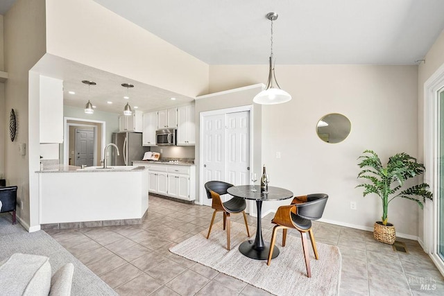 dining room with light tile patterned flooring, baseboards, and lofted ceiling