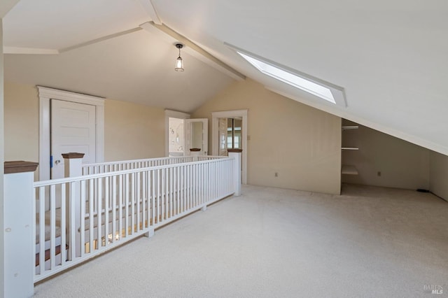 additional living space featuring vaulted ceiling with skylight and carpet floors