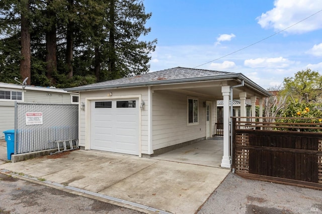 garage featuring driveway and fence