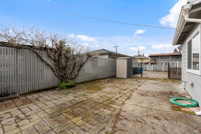 view of patio / terrace with a storage shed, an outdoor structure, and a fenced backyard