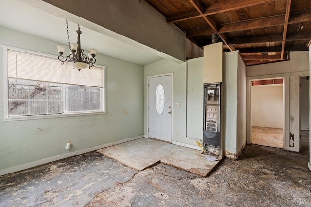 foyer entrance featuring a chandelier and baseboards