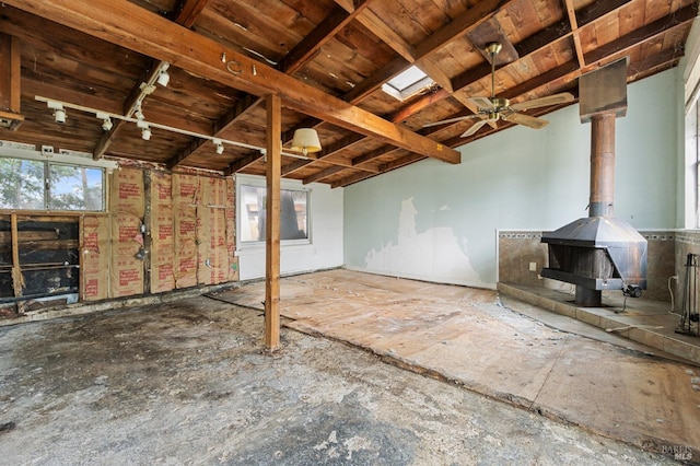 interior space featuring a wood stove and a ceiling fan