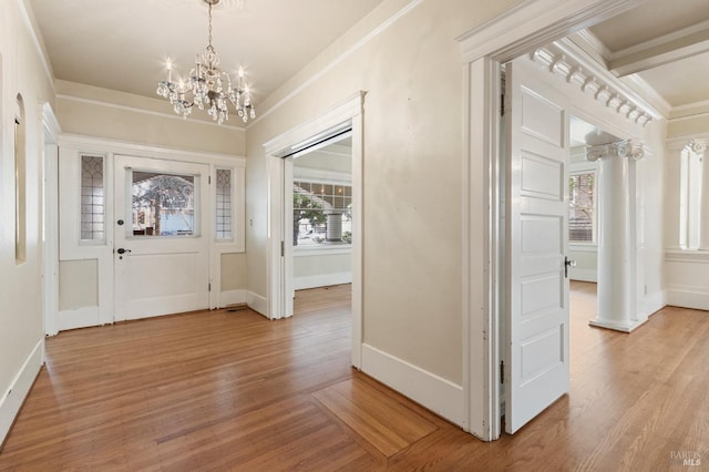 entryway with a chandelier, plenty of natural light, light wood-type flooring, and crown molding