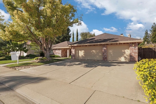 view of front facade featuring brick siding, concrete driveway, an attached garage, and fence