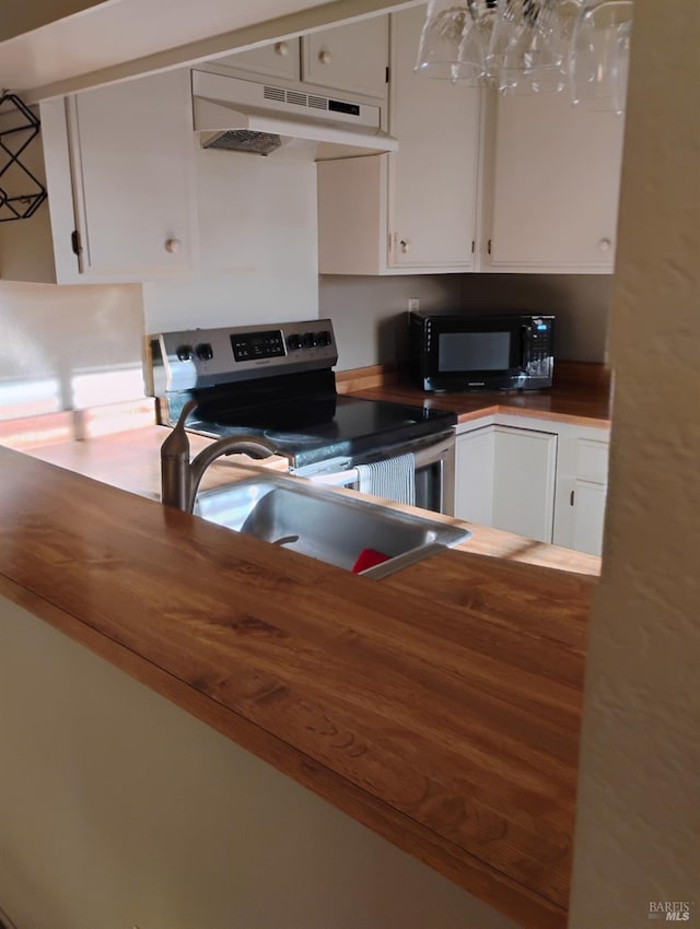 kitchen with electric stove, under cabinet range hood, white cabinetry, black microwave, and wooden counters