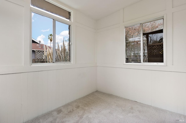 carpeted empty room featuring a decorative wall