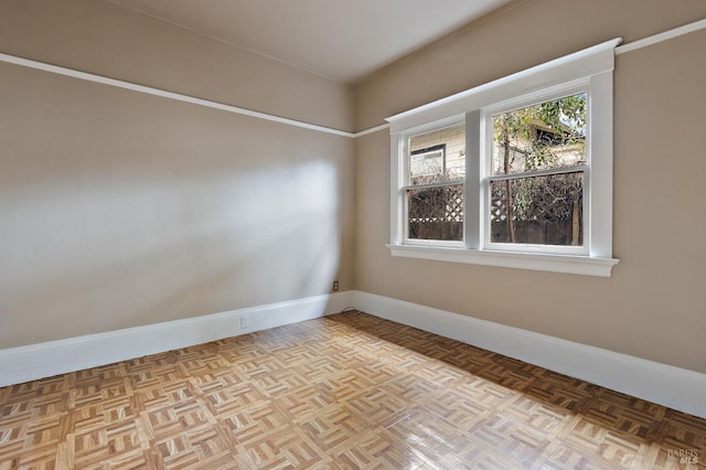 unfurnished room with baseboards