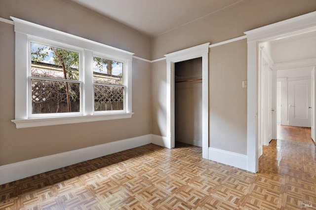 unfurnished bedroom with a closet and baseboards