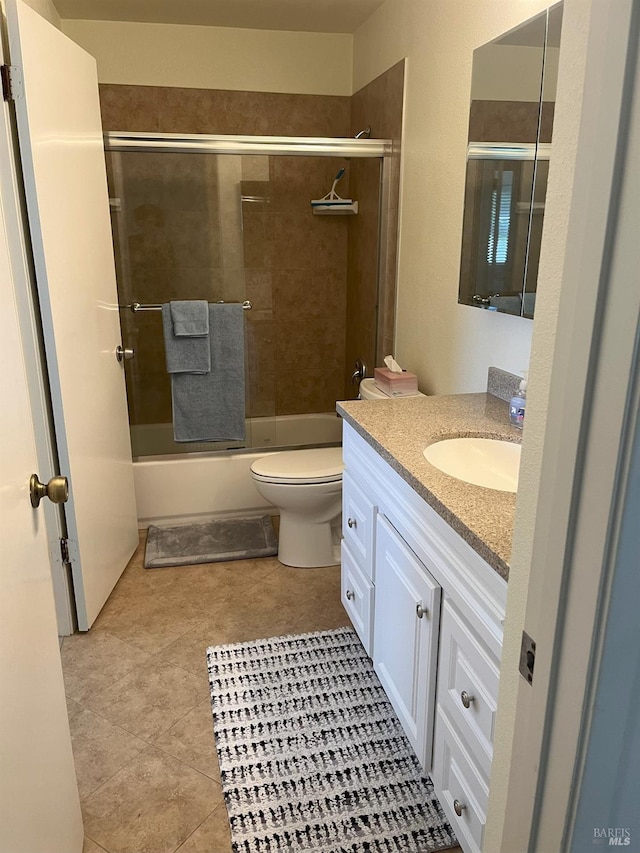 full bathroom with vanity, tile patterned floors, toilet, and combined bath / shower with glass door