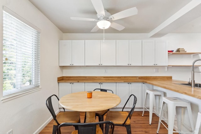 dining space with wood finished floors, baseboards, and ceiling fan