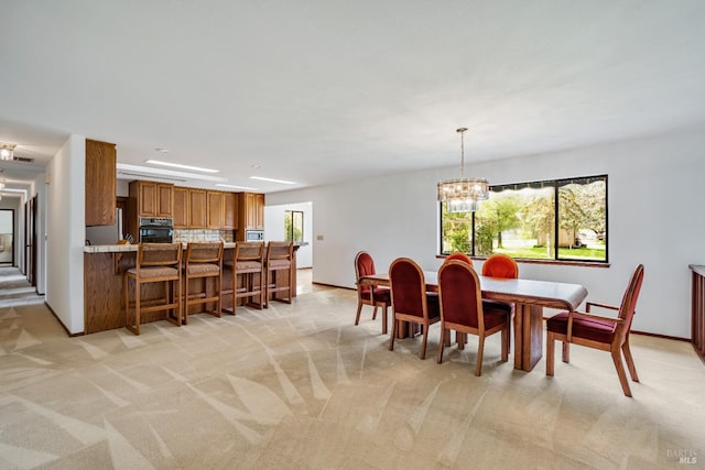 dining room with baseboards, light carpet, and an inviting chandelier