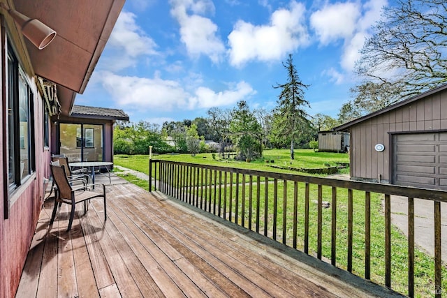 wooden terrace with a garage and a lawn