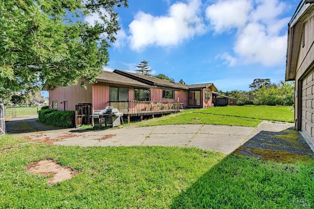 back of property featuring a lawn and a wooden deck