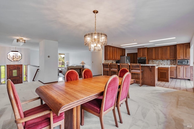 dining space with light carpet and an inviting chandelier