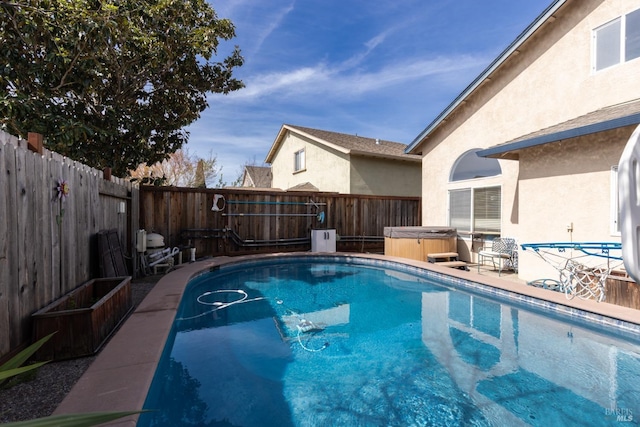 view of pool with a fenced in pool, a fenced backyard, and a hot tub