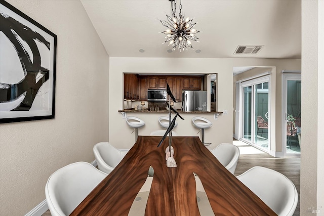 dining room featuring an inviting chandelier, baseboards, and visible vents