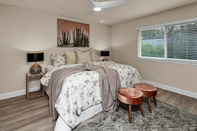 bedroom featuring a ceiling fan, baseboards, and wood finished floors