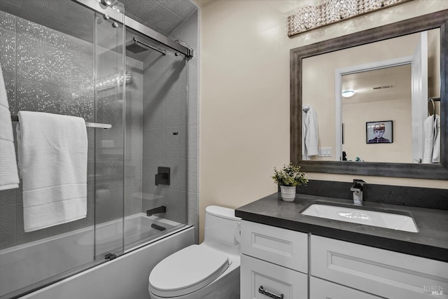 full bath featuring enclosed tub / shower combo, toilet, and vanity