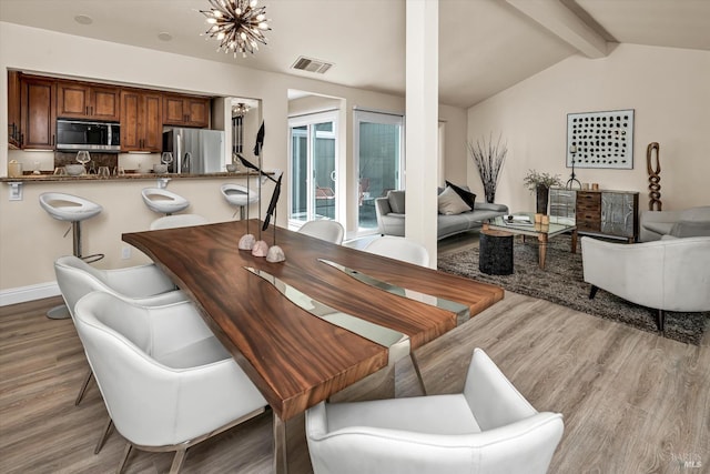 dining room with visible vents, an inviting chandelier, vaulted ceiling with beams, and light wood finished floors