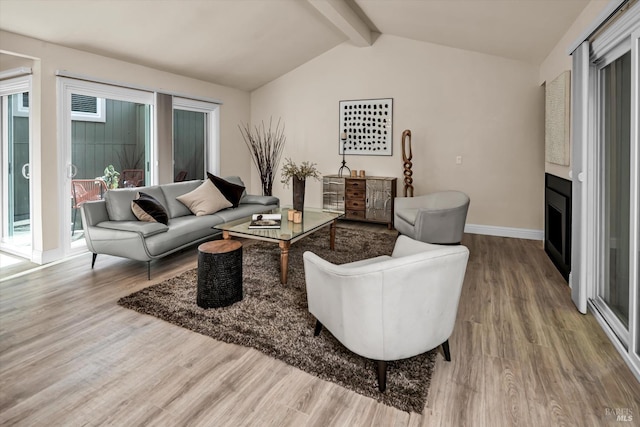 living room with a fireplace, lofted ceiling with beams, baseboards, and wood finished floors