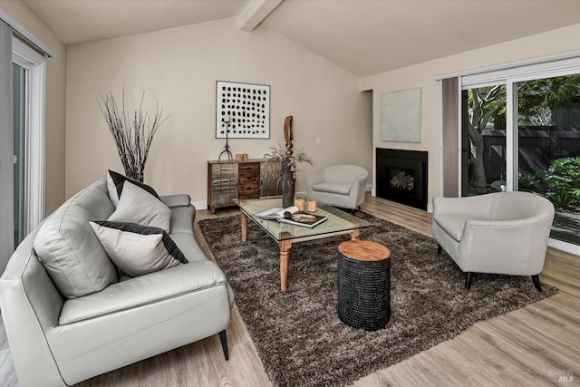 living room with baseboards, a fireplace, wood finished floors, and vaulted ceiling with beams