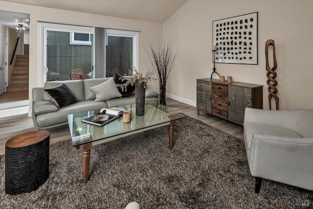 living room with baseboards, stairs, lofted ceiling, and wood finished floors