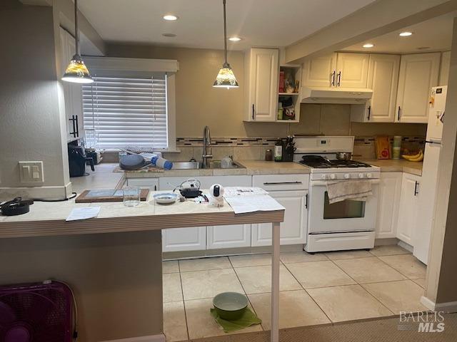 505 Petaluma Blvd N, Petaluma, CA 94952 - kitchen with a sink, white gas range oven, under cabinet range hood, light countertops, and white cabinets