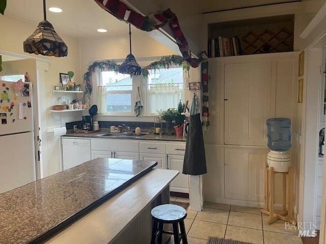 505 Petaluma Blvd N, Petaluma, CA 94952 - kitchen featuring white appliances, a sink, white cabinets, light tile patterned floors, and hanging light fixtures