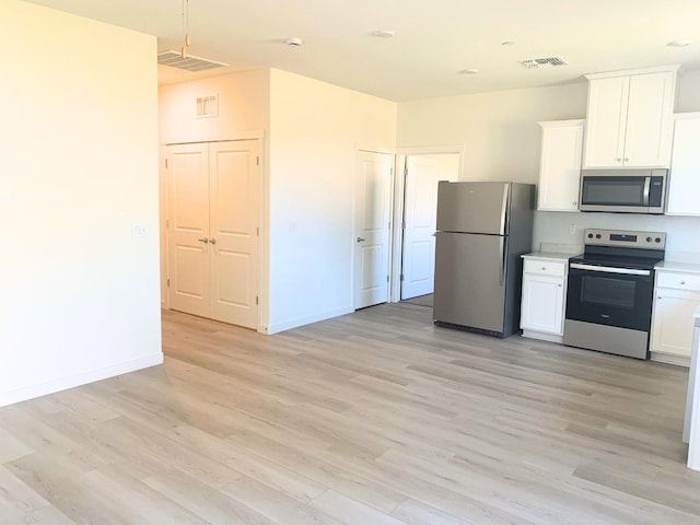 kitchen with light wood finished floors, visible vents, white cabinets, and appliances with stainless steel finishes