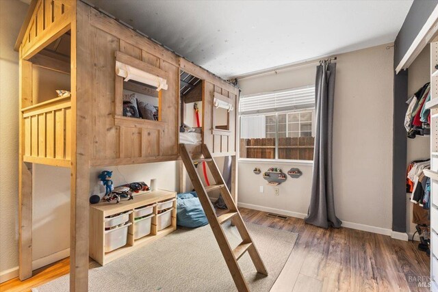 bedroom with wood finished floors and baseboards
