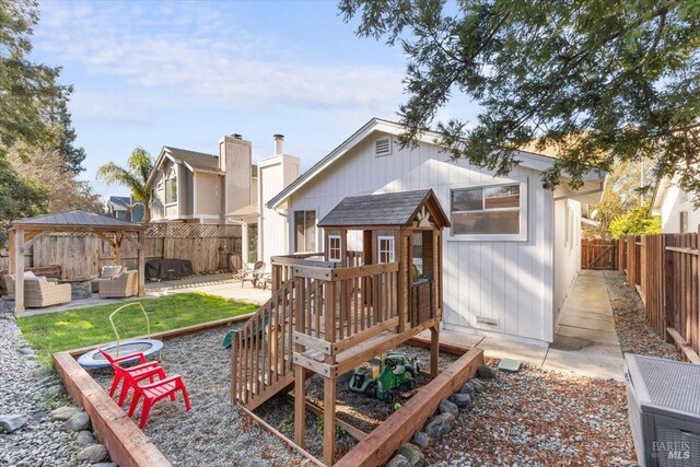 back of property with a gazebo, a patio area, outdoor lounge area, and a fenced backyard
