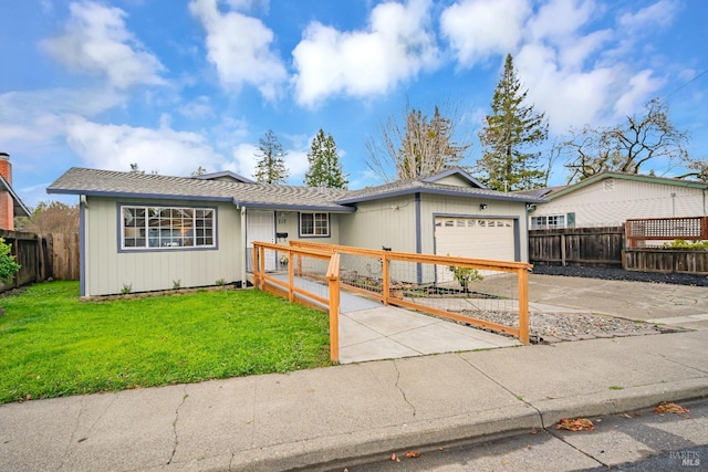 ranch-style house with concrete driveway, a front yard, a garage, and a fenced front yard