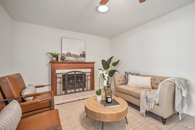 living room with tile patterned floors, a ceiling fan, and a tile fireplace