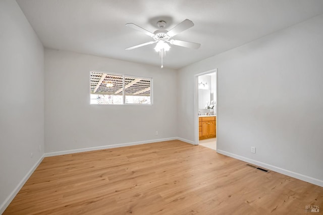 empty room featuring visible vents, baseboards, light wood-type flooring, and ceiling fan