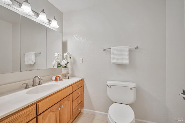 bathroom featuring tile patterned flooring, toilet, vanity, and baseboards