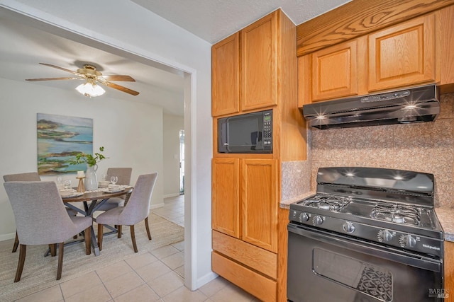 kitchen with light tile patterned floors, a ceiling fan, decorative backsplash, black appliances, and under cabinet range hood