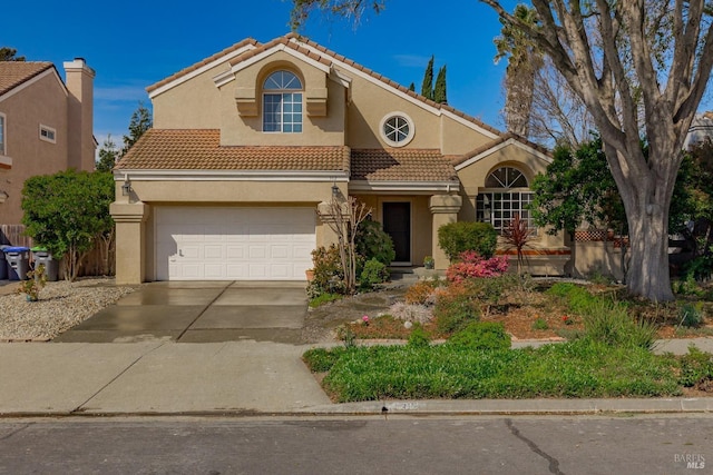 mediterranean / spanish-style house with a tiled roof, a garage, driveway, and stucco siding