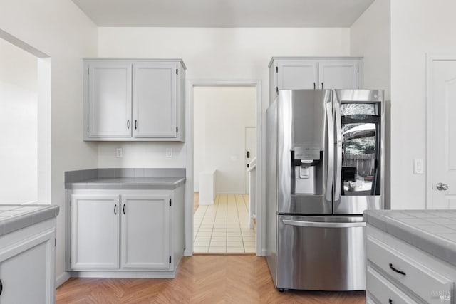 kitchen featuring tile countertops and stainless steel fridge